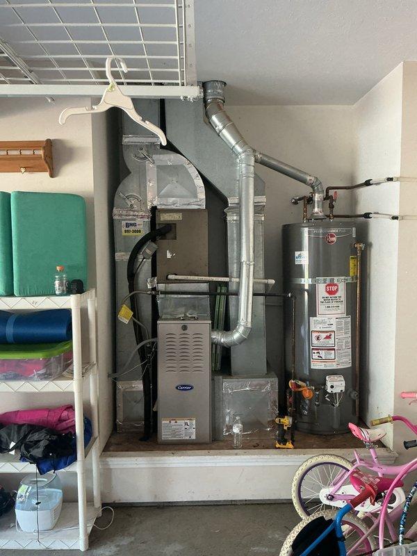 Conducted comprehensive on-site evaluation for complete HVAC system replacement. Assessed existing Carrier furnace installation and associated ductwork configuration in residential garage utility closet, documented current equipment specifications and spatial constraints for new system design. Photographed exterior gas meter connections, electrical service panel locations, and interior mechanical room layout to determine optimal equipment sizing and installation requirements for Green - A+ rated replacement system.
