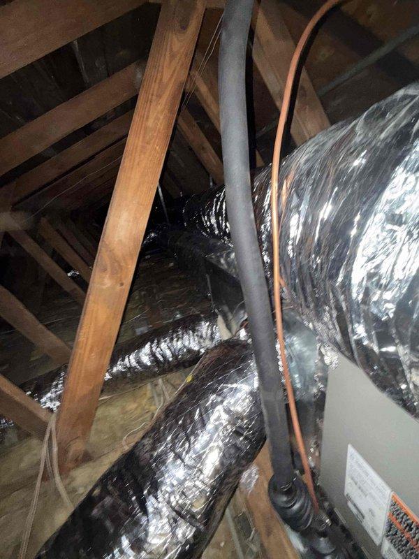 Completed day two of a full HVAC system installation featuring a 4-ton, 15.5 SEER air conditioning unit paired with an 80% efficiency furnace. Installed flexible ductwork throughout the attic space, routed between structural joists and rafters, ensuring proper airflow distribution to all living areas. Mounted new supply register with horizontal louvers in the ceiling, integrated with existing beadboard paneling and trim work to maintain the home's interior aesthetic.