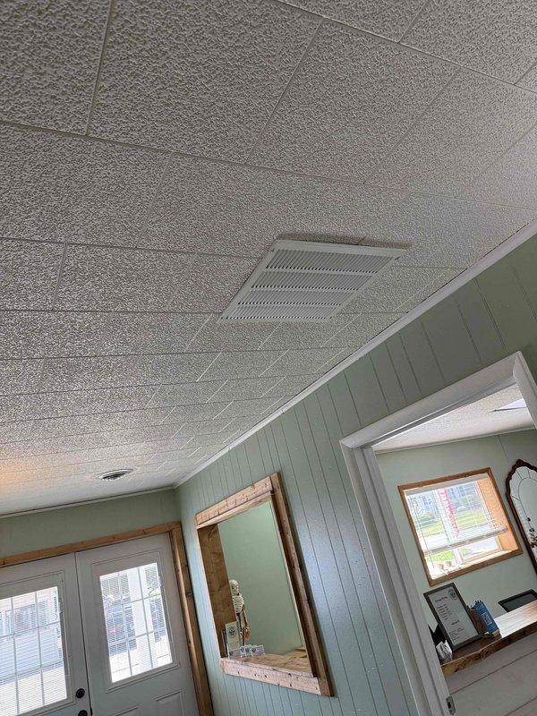 Completed day two of a full HVAC system installation featuring a 4-ton, 15.5 SEER air conditioning unit paired with an 80% efficiency furnace. Installed flexible ductwork throughout the attic space, routed between structural joists and rafters, ensuring proper airflow distribution to all living areas. Mounted new supply register with horizontal louvers in the ceiling, integrated with existing beadboard paneling and trim work to maintain the home's interior aesthetic.