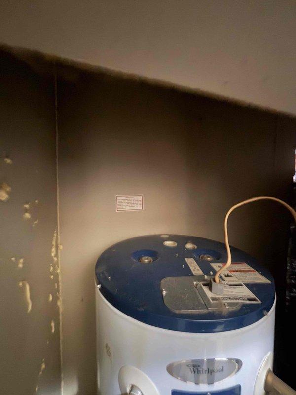 Responded to service call for malfunctioning thermostat on 6-year-old heat pump system that would not shut off, causing temperature discrepancy between actual (68°F) and setpoint (71°F). Upon inspection, assessed existing Whirlpool water heater (Model MHE2F40RS035V) showing signs of age and determined replacement was necessary. Provided on-site estimate for new water heater installation and obtained approval for equipment upgrade to resolve household hot water needs.
