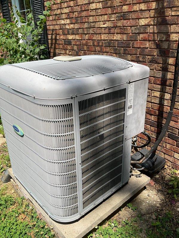 # HVAC Service Report

Responded to no-cooling complaint with breaker tripping issue on 10-year-old Carrier air conditioning system. Upon arrival, confirmed unit was tripping breaker even in off position, indicating potential electrical short or compressor failure. Performed diagnostic evaluation of outdoor condenser unit and indoor thermostat operation. Documented system condition with thermostat set to 68°F displaying 76°F ambient temperature. Inspected outdoor unit positioned on concrete pad against brick wall, noting refrigerant line connections and overall system configuration. Verified no ice buildup present at indoor coil location. Given age of equipment and nature of electrical fault, recommended replacement options as most cost-effective solution versus major component repair on decade-old system approaching end of typical service life.