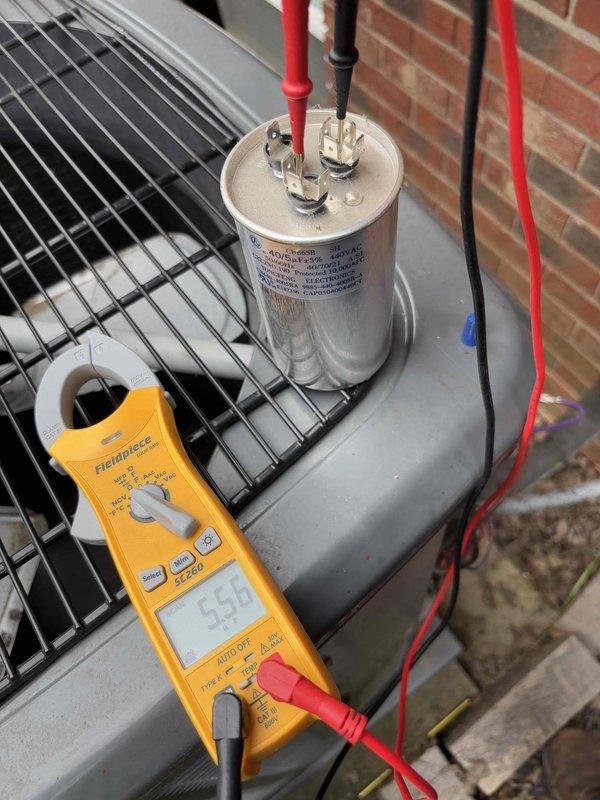 Responded to no cooling complaint on residential air conditioning system. Upon arrival, found thermostat displaying 86°F with unit running but not producing cold air. Performed diagnostic testing on outdoor condensing unit using digital multimeter. Testing revealed failed capacitor preventing compressor from operating properly. Replaced defective dual-run capacitor with new unit, verified proper microfarad readings, and confirmed all electrical connections secure. System tested successfully with compressor engaging and cold air production restored to normal operation.