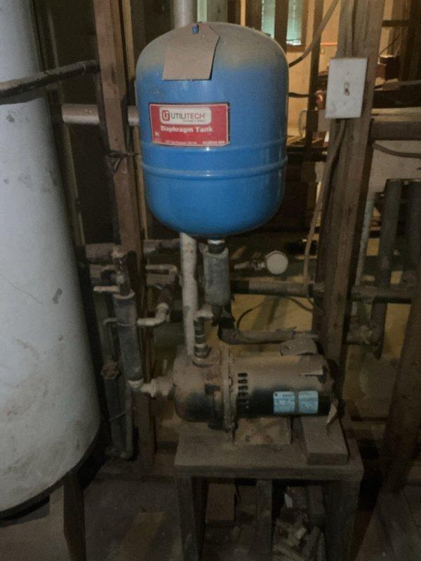 Responded to service call for water heater and well pump inspection following previous flood damage that resulted in 8 feet of water in the home. Upon arrival, conducted thorough assessment of existing U.S. Craftmaster water heater with 6.75M capacity, which exhibited significant deterioration including extensive rust staining, discoloration, and visible wear throughout the tank exterior, particularly concentrated on the lower third of the unit. Inspected well pump system including blue pressurized expansion tank mounted on metal frame platform and horizontal circulation pump with associated piping connections. Documented condition of all equipment with photographs showing compromised water heater condition likely resulting from flood exposure. Evaluated pressure tank, pump assembly, copper piping, valves, and electrical connections for proper operation and signs of water damage. Provided customer with assessment findings regarding water heater condition and recommendations for replace