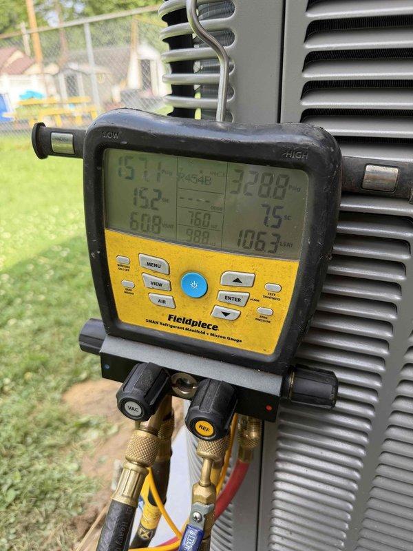 Completed full HVAC system installation including a 2-ton, 14.7 SEER outdoor condensing unit and 80% AFUE furnace in basement mechanical room. Performed system startup, refrigerant charging, and verification of proper operation using manifold gauges with measured temperatures of 151.7°F and 152°F and pressures of 228.9 and 106.3 PSI, confirming system is operating within manufacturer specifications.