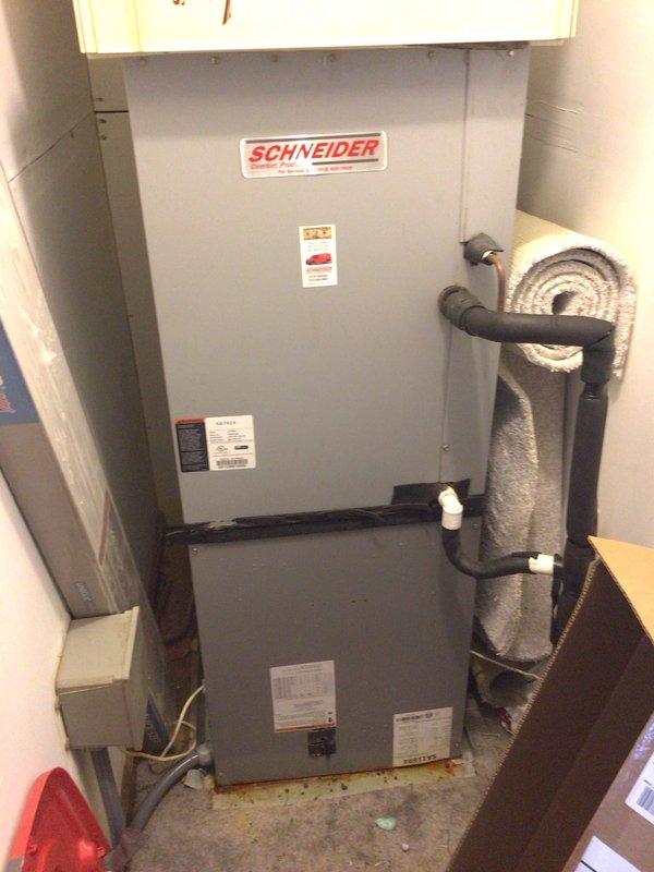 Conducted comprehensive HVAC system assessment for equipment replacement estimate. Evaluated existing Schneider brand split system installation showing signs of age, wear, and floor staining indicating potential condensate drainage issues. Documented current air handler unit with visible dust accumulation and discoloration, along with evaporator coil condition. Photographed equipment specifications, refrigerant line routing, electrical connections, and overall system configuration in confined mechanical room space. Provided detailed documentation and replacement recommendations for upgraded energy-efficient system.