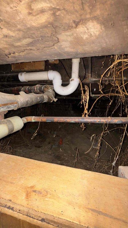 Conducted comprehensive HVAC system replacement estimate for property currently relying on window units. Assessment included evaluation of unfinished basement space with exposed infrastructure and crawl space conditions, identifying need for complete ductwork installation in addition to new air conditioning system. Documented existing conditions including moisture concerns evidenced by dehumidifier presence in basement, aged plumbing infrastructure with corrosion, and structural considerations for new duct routing through exposed joists and support beams. Provided detailed replacement specifications for full HVAC system installation including proper duct design to serve all conditioned spaces.