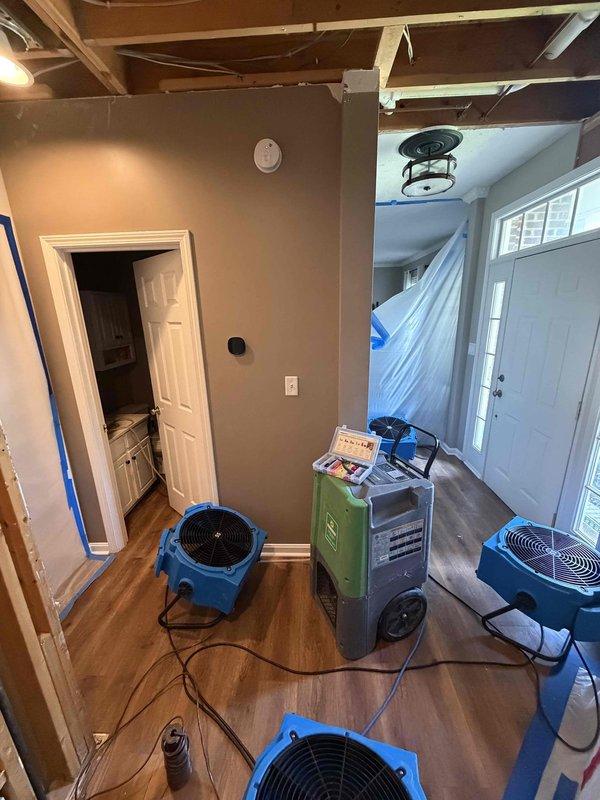 Responded to no cooling complaint on 1-year-old residential HVAC system. Upon arrival, found property undergoing active water damage restoration with multiple air movers and dehumidifier operating throughout the living space. Customer reported system running but not cooling, with breaker tripping incident several days prior. Performed diagnostic evaluation of air conditioning system. Determined system operational issues related to ongoing restoration work and environmental conditions within the structure. Advised customer on proper system operation during remediation process and recommended follow-up assessment once restoration work is completed and normal environmental conditions are restored.