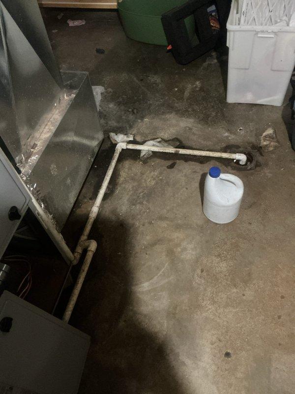 Responded to emergency service call for central air conditioning system reported to be leaking while maintaining cooling operation. Upon arrival, conducted thorough inspection of HVAC system and surrounding utility area. Identified active water leak originating from condensate drainage system. Traced condensate line routing through basement mechanical room and discovered blockage causing overflow condition. Cleared obstruction from condensate drain line and verified proper drainage flow. Inspected evaporator coil drain pan for cracks or deterioration and confirmed structural integrity. Tested system operation under load to ensure condensate removal functioning correctly. Cleaned up standing water from concrete floor using wet vacuum. Monitored system through complete cooling cycle to verify leak resolution and confirm no further water discharge onto floor. System restored to normal operation with proper condensate drainage established.