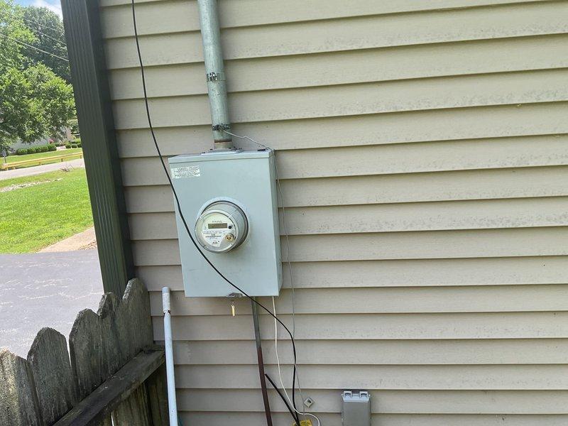 Conducted comprehensive on-site electrical estimate for residential backup generator installation. Assessed existing electrical infrastructure including main service panel with breaker configuration and digital utility meter mounted on exterior wall with metallic conduit. Evaluated natural gas supply system and existing gas meter installation at foundation level to determine fuel source compatibility for proposed generator system. Documented current electrical service entrance configuration, meter base location, and available space for generator placement and automatic transfer switch installation. Reviewed site conditions including clearance requirements, utility access points, and optimal positioning for generator unit relative to existing gas line and electrical panel. Confirmed adequate natural gas supply capacity and verified proper grounding and bonding requirements for code-compliant installation.