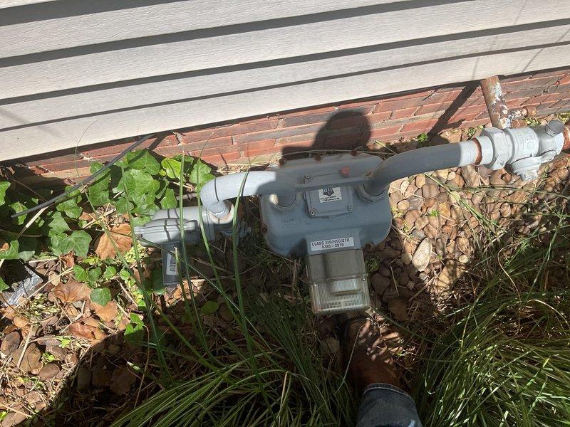 Conducted comprehensive on-site electrical estimate for residential backup generator installation. Assessed existing electrical infrastructure including main service panel with breaker configuration and digital utility meter mounted on exterior wall with metallic conduit. Evaluated natural gas supply system and existing gas meter installation at foundation level to determine fuel source compatibility for proposed generator system. Documented current electrical service entrance configuration, meter base location, and available space for generator placement and automatic transfer switch installation. Reviewed site conditions including clearance requirements, utility access points, and optimal positioning for generator unit relative to existing gas line and electrical panel. Confirmed adequate natural gas supply capacity and verified proper grounding and bonding requirements for code-compliant installation.