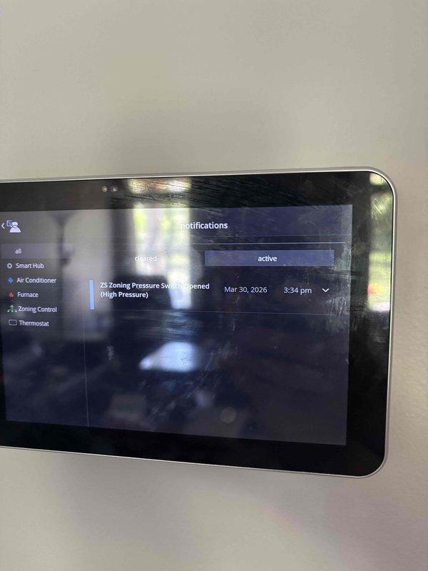 Completed complimentary planned HVAC maintenance tune-up on residential system. Documented zoning system pressure switch notification showing high pressure alert on smart home control interface. Measured and recorded attic temperature at 51°F using calibrated digital instrumentation over foil-faced insulation, verifying proper environmental conditions in equipment area.