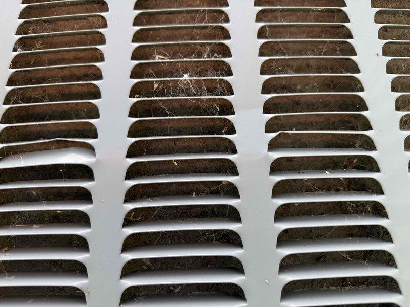 Responded to no cooling complaint on nine-year-old residential air conditioning system. Upon arrival, confirmed unit was running but delivering warm air to living space with no cold air production. Performed diagnostic evaluation of outdoor condensing unit and indoor air handler components. Identified heavily soiled return air grille with significant dust and debris accumulation restricting proper airflow through the system. Cleaned contaminated ventilation components and verified refrigerant lines, electrical connections, and condenser operation. System restored to normal cooling operation with adequate airflow and proper temperature differential across evaporator coil.