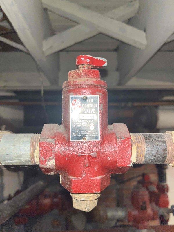Conducted comprehensive on-site assessment of existing residential boiler system for replacement estimate. Evaluated aged boiler unit with associated piping, control valves, circulator pump, and electrical components. Documented current system configuration including red-handled control valve assembly with threaded brass connections, vintage boiler with multiple supply and return lines, basement mechanical room layout, and existing ductwork infrastructure. Photographed equipment conditions showing signs of age and wear on control mechanisms and boiler surfaces. Assessed mechanical room accessibility, structural considerations, and existing utility connections to provide accurate replacement specifications and recommendations.
