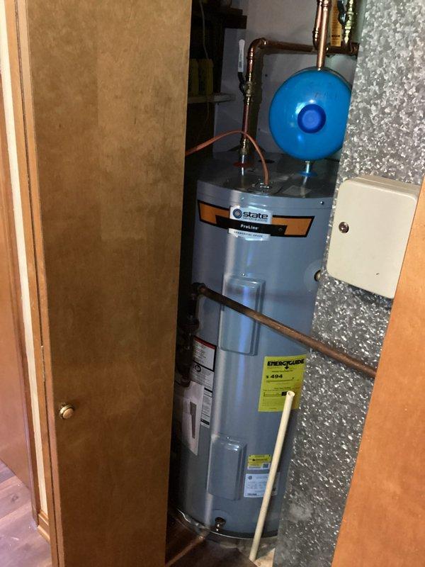 Completed installation of 50-gallon State ProLine electric water heater in residential utility closet. Installed blue expansion tank with proper copper piping connections, brass fittings, and appropriate routing. Unit mounted with drain pan, all plumbing connections secured, and system tested for proper operation.