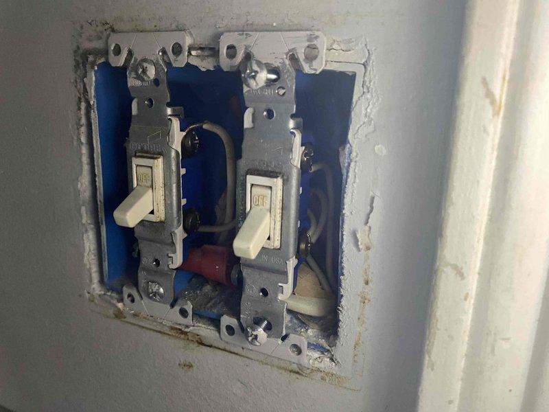 Responded to report of crackling and sparking noises from bathroom light switch. Upon arrival, inspected the double toggle switch installation and found compromised wiring connections within the electrical box. Removed wall plate to access the switches and identified arcing damage at wire terminations. Replaced faulty double switch assembly, secured all wire connections with proper torque specifications, and verified ground continuity. Tested both switch circuits under load to ensure proper operation without arcing or abnormal sounds. Reinstalled wall plate and restored power to bathroom lighting circuits. All electrical components now functioning safely within code specifications.
