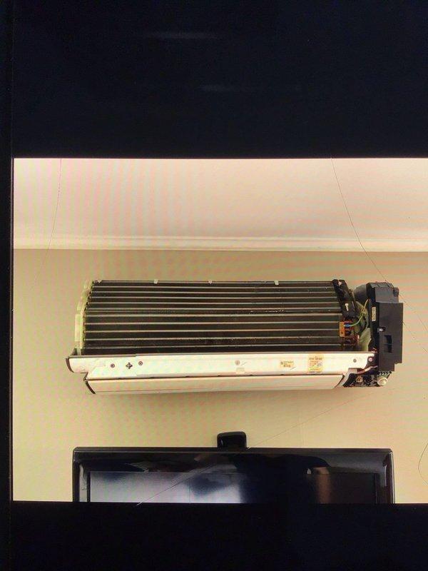 Responded to no cooling complaint on 7-year-old upstairs ductless mini-split system blowing room temperature air with frost accumulation on interior unit. Upon inspection, removed cover and accessed evaporator coil assembly to diagnose cooling loss. Found evidence of refrigerant flow restriction causing inadequate heat exchange and frost buildup on coil surfaces. Performed system diagnostics including temperature differential measurements and visual inspection of heat exchanger components. Identified airflow present but insufficient cooling capacity due to frost-restricted evaporator coil. Advised system defrost protocol and verified proper fan motor operation on black housing assembly.