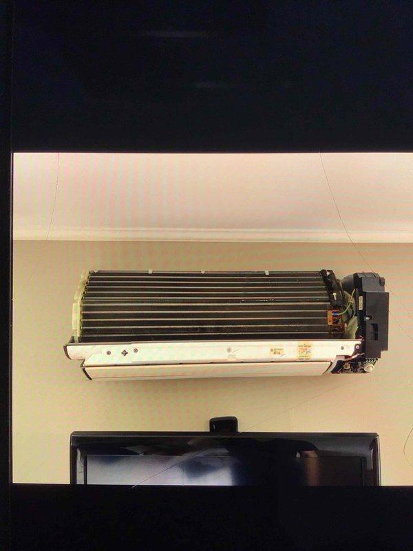 Responded to no cooling complaint on 7-year-old upstairs ductless mini-split system blowing room temperature air with frost accumulation on interior unit. Upon inspection, removed cover and accessed evaporator coil assembly to diagnose cooling loss. Found evidence of refrigerant flow restriction causing inadequate heat exchange and frost buildup on coil surfaces. Performed system diagnostics including temperature differential measurements and visual inspection of heat exchanger components. Identified airflow present but insufficient cooling capacity due to frost-restricted evaporator coil. Advised system defrost protocol and verified proper fan motor operation on black housing assembly.