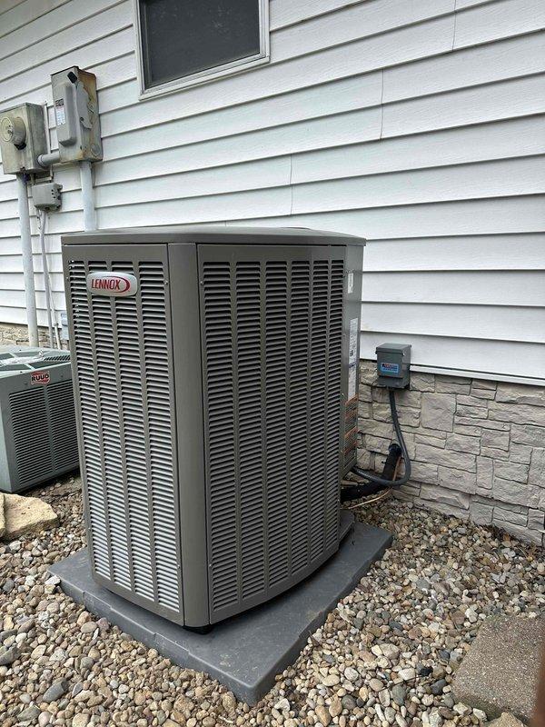 Completed full HVAC system replacement including installation of new 2-ton, 18 SEER, 97% AFUE Lennox equipment. Installed outdoor condensing unit on composite pad with proper gravel base and stone veneer backdrop, including electrical disconnect box and conduit run. Interior furnace unit positioned in utility alcove with white flexible ductwork connections, proper clearances maintained, and all manufacturer specifications followed for optimal system performance and efficiency.