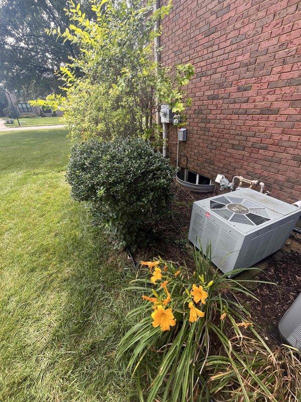 Conducted comprehensive site evaluation for residential cooling system replacement. Existing air conditioning unit assessed at 28 years of service life, having reached end of expected operational lifespan. Documented current outdoor condensing unit configuration, utility connections including gas meter proximity, electrical service boxes, refrigerant line routing, and condensate drainage system. Photographed equipment placement against brick structure with surrounding landscaping considerations for future installation planning. Provided detailed replacement estimate for new cooling system with recommendations for modern high-efficiency equipment upgrade.
