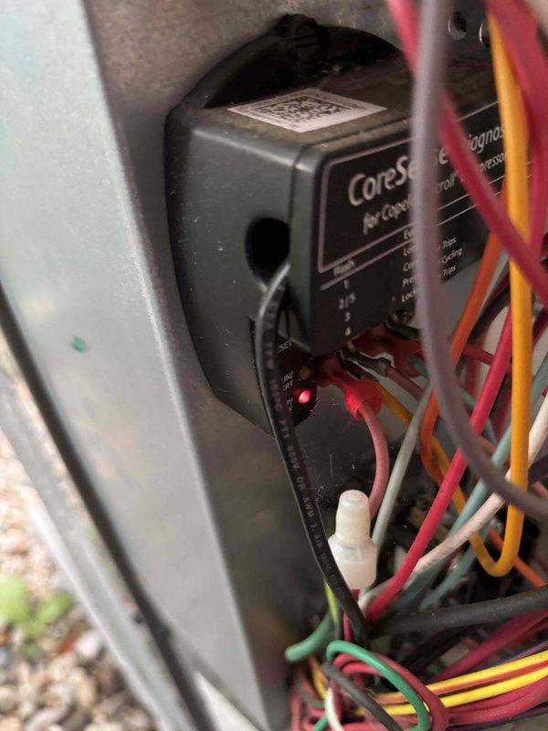 Responded to no cooling call on 4-year-old residential air conditioning system with outdoor unit completely inoperative. Upon arrival, verified outdoor condenser unit had no power and was not running despite homeowner's previous attempts to reset breaker. Inspected main electrical panel and located dedicated AC circuit breaker in proper position. Proceeded to outdoor disconnect and found CoreSense Air Controls hard start capacitor device with illuminated LED indicator, suggesting control board had power but was not sending signal to compressor contactor. Diagnosed failed compressor contactor coil preventing outdoor unit from receiving proper voltage. Replaced defective contactor with new component, restored power to system, and verified compressor and condenser fan motor started properly. Tested system operation through complete cooling cycle, confirmed proper amperage draw on all components, and verified thermostat communication with outdoor unit. System restored to full operational s