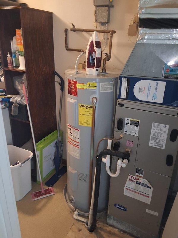 Conducted comprehensive site visit and estimate for residential HVAC system, documenting existing air handler unit, vertical ductwork configuration, and water heater installation in utility room. Captured detailed photos of equipment specifications, manufacturer labels, and current mechanical room layout for proposal preparation and sales follow-up.