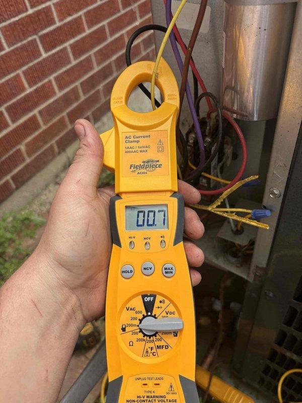 Responded to no cooling complaint on 7-year-old residential air conditioning system blowing warm air. Upon arrival, confirmed adequate airflow through vents with no ice buildup on evaporator coil. Performed diagnostic testing using digital thermometer and clamp meter at outdoor condensing unit. Measured supply air temperature at 53°F, indicating insufficient cooling capacity. Checked electrical current draw at compressor circuit showing 7 amps, which is below normal operating amperage for typical residential compressor. Inspected condenser unit wiring connections and contactor operation. Low amperage reading combined with warm air delivery suggests potential compressor failure or refrigerant loss requiring further system evaluation.