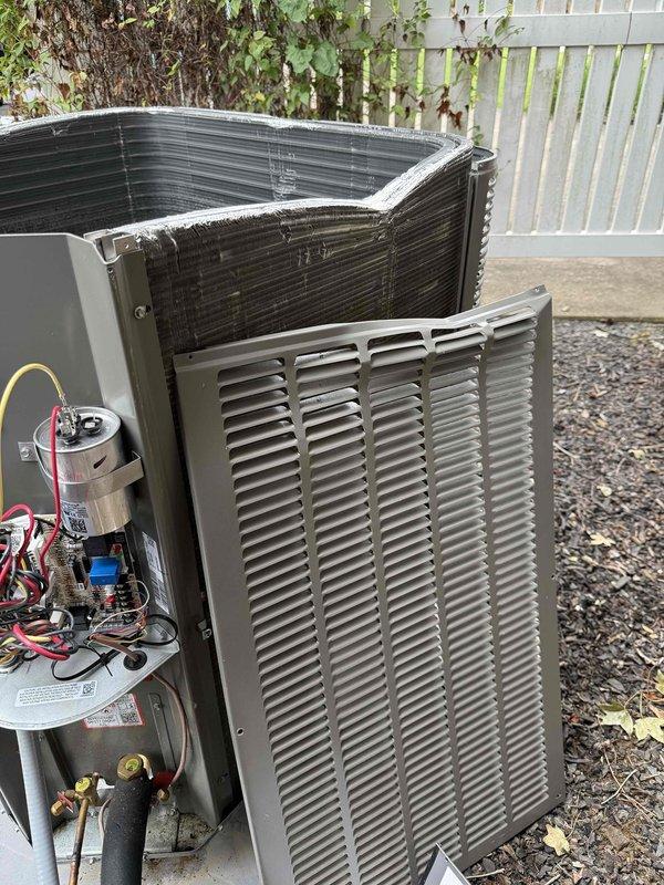 Responded to service call for outdoor AC unit damaged by falling tree limb. Upon arrival, inspected less than one-year-old unit and found visible damage to top housing with reported vibration and noise issues. Removed access panel to assess internal components including blower assembly, capacitor, wiring connections, and refrigerant lines for impact damage. Documented unit condition with photos showing external housing damage and internal component inspection. System had not been operated since incident occurred due to safety concerns.
