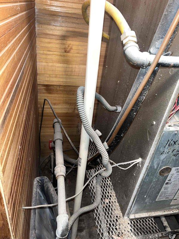 Conducted comprehensive HVAC system evaluation for non-functional air conditioning unit in recently purchased residential property. Assessed existing outdoor condensing unit located in narrow utility area alongside gas lines, electrical conduits, and plumbing infrastructure, noting equipment condition and accessibility constraints. Inspected basement-installed furnace system with vertical venting configuration, evaluated existing ductwork, and documented current equipment specifications. Provided complete replacement estimate options and discussed available financing solutions for full HVAC system installation.
