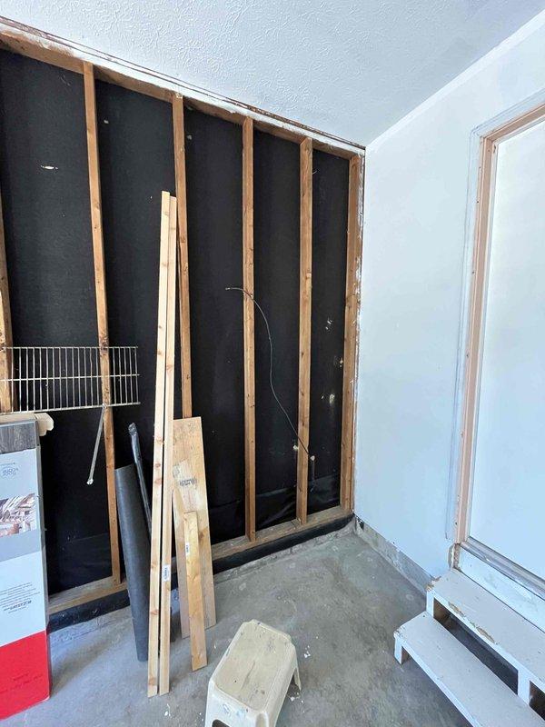 Completed on-site estimate for mini-split installation in garage and replacement of existing tank-style electric water heater with 40 or 50-gallon unit. Assessed current working water heater showing age-related wear and staining, documented existing plumbing connections and venting configuration, and evaluated garage space with exposed framing for ductless mini-split system placement.