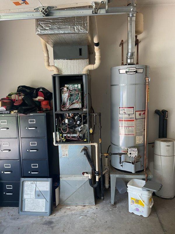Completed scheduled HVAC maintenance tune-up on residential split system including indoor furnace unit and outdoor condensing unit. Performed comprehensive inspection of furnace components with access panel removed, examining blower motor assembly, electrical connections, circuit boards, and ductwork connections. Inspected outdoor condensing unit with top panel removed, evaluating capacitor condition, contactor operation, electrical wiring integrity, and internal components. All system components found operational with wiring connections intact throughout both units.