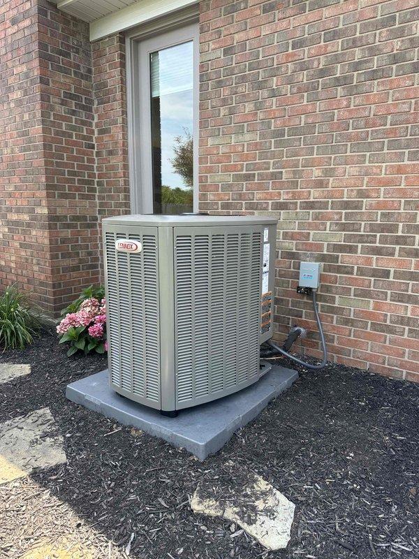Completed installation of 3-ton, 19 SEER heat pump system with matching air handler and 50-gallon electric water heater. Lennox outdoor condensing unit was positioned on concrete pad against brick exterior with proper clearances, electrical disconnect installed, and all refrigerant lines connected. Interior air handler and water heater were installed and fully commissioned, with all equipment tested and confirmed operational.