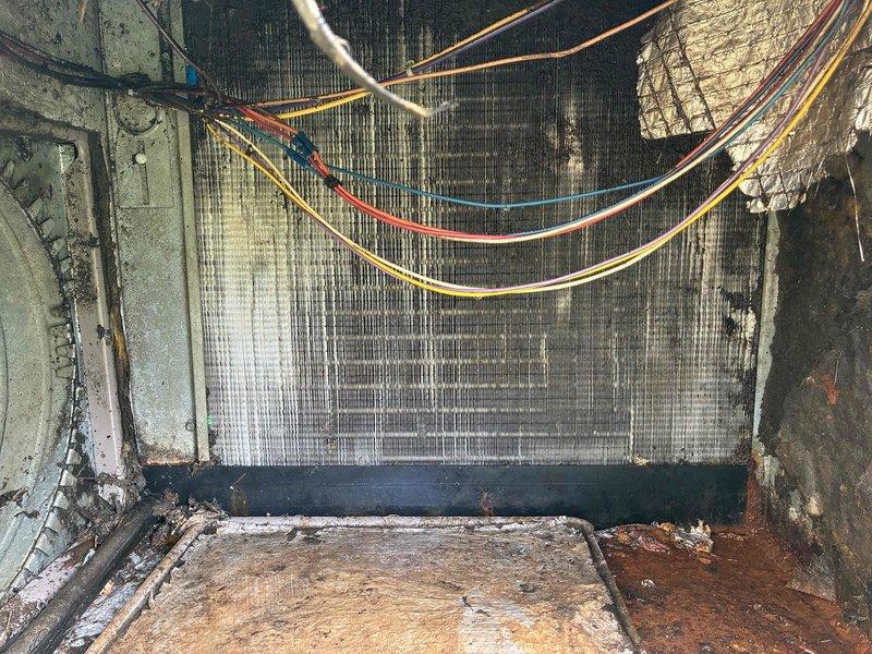# HVAC Repair Completed

Responded to no cooling complaint on residential air conditioning system. Upon inspection, found evaporator coil assembly with significant corrosion and deterioration to surrounding metal housing and drain pan. Electrical control panel showed multiple signs of age-related wear including dust accumulation, oxidation on components, and disorganized wiring connections. 

Performed comprehensive diagnostic evaluation of the system. Tested capacitor functionality and verified all electrical connections at control board and terminal blocks. Inspected relay and contactor operation. Assessed evaporator coil for airflow restrictions and verified proper refrigerant circuit integrity. Cleaned accumulated debris from base pan and coil assembly.

Completed necessary repairs to restore cooling operation. System tested and verified operational upon completion. Total repair time: 2 hours.