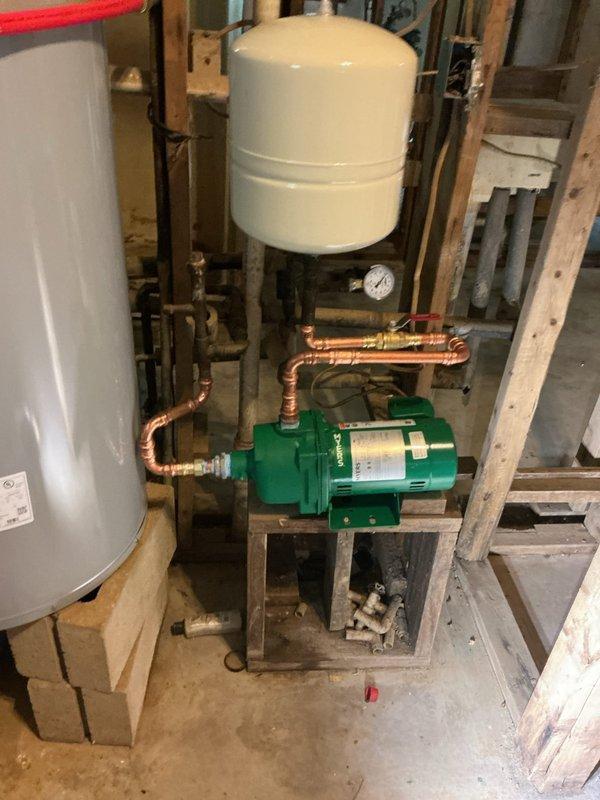 Completed warranty follow-up visit to finalize previous water heater installation after electrical power was restored to the system. Previously installed 50-gallon electric water heater with new ball valves and replaced shallow well water pump with pressure tank and copper piping connections. Return visit scheduled to replace 5 shut-off valves, perform minor reciprocating work on shut-offs, and relocate shower head to new position per specifications.