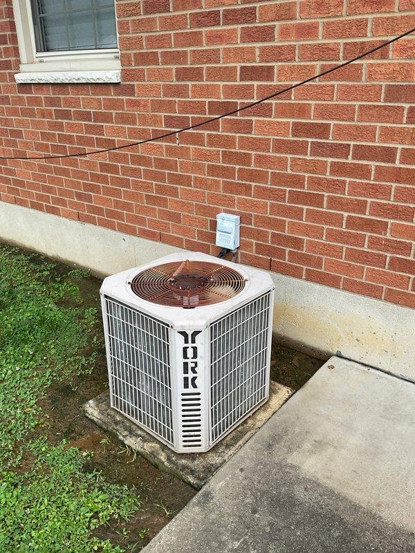 Completed comprehensive HVAC system replacement estimate for aging residential cooling system. Evaluated existing York brand outdoor condensing unit positioned on concrete pad against brick exterior, noting electrical disconnect and refrigerant line routing. Assessed interior components including basement installation with PVC condensate drainage system and associated plumbing connections. Provided detailed replacement recommendations for complete system upgrade to improve efficiency and reliability.