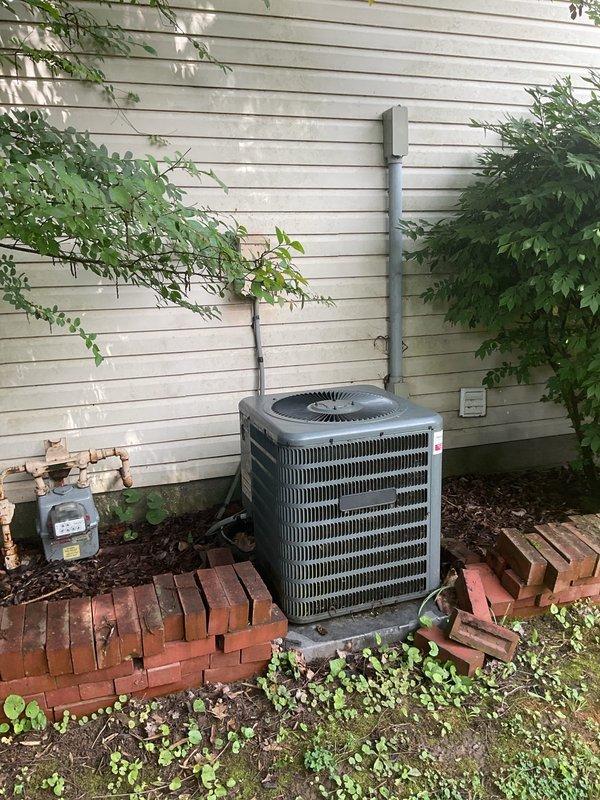 Conducted comprehensive replacement estimate for non-operational residential air conditioning system. Evaluated existing outdoor condensing unit mounted on brick platform against house exterior, assessed electrical conduit and disconnect box configuration, and inspected indoor thermostat wiring connections to determine compatibility requirements for new equipment installation.