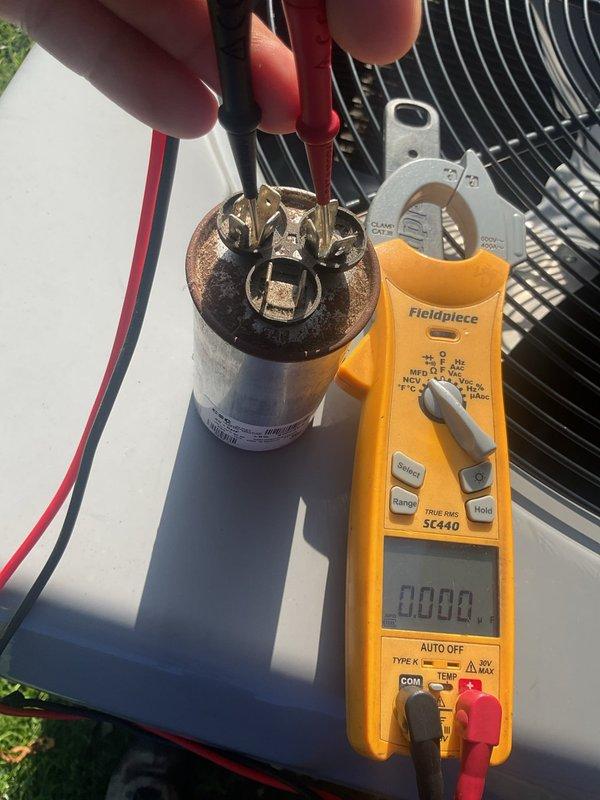 Responded to no cooling complaint on 6-year-old residential air conditioning system with thermostat set to 70°F but home temperature at 75°F. Upon inspection, tested the outdoor unit's capacitor using multimeter and found failed capacitor with 0.000 reading. Replaced defective capacitor, verified proper electrical connections, and restored system to normal cooling operation.