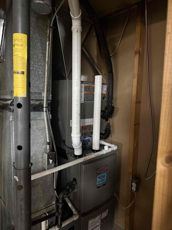 Completed full HVAC system installation including a 2-ton, 16 SEER air conditioning unit paired with a 96% efficiency upflow furnace, 40-gallon State brand water heater, and sump pump system. All equipment was installed in the basement utility area with proper venting using white PVC piping, copper water connections to the water heater, and appropriate ductwork connections. The furnace was mounted against the back wall with condensate drain lines properly routed, electrical connections completed, and all safety labels visible and intact. The water heater was positioned adjacent to the HVAC unit with supply and discharge piping installed to code. All components were tested for proper operation and the installation area was left clean and organized.