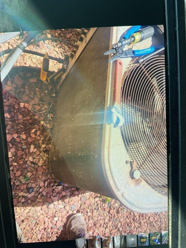 Responded to no cooling complaint on residential air conditioning system with warm air blowing from vents. Performed diagnostic evaluation of outdoor condensing unit and refrigerant system components. Inspected condenser unit exterior condition, copper refrigerant line connections, and service valve access points to determine cause of cooling failure and assess system performance.
