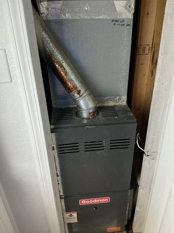 Responded to no cooling complaint on 20+ year old Goodman HVAC system with weak airflow. Upon arrival, found system running but not producing adequate cooling. Performed diagnostic inspection revealing severely restricted airflow due to heavily clogged air filter with excessive dust and debris accumulation. Observed significant rust and corrosion on supply duct piping extending from furnace unit, indicating advanced age and deterioration of system components. Replaced dirty 16x25x1 air filter with new filter to restore proper airflow. Advised property owner that system age and visible component deterioration, including corroded ductwork, indicate unit is operating well beyond typical service life and may require replacement in near future to avoid continued performance issues and potential system failure.