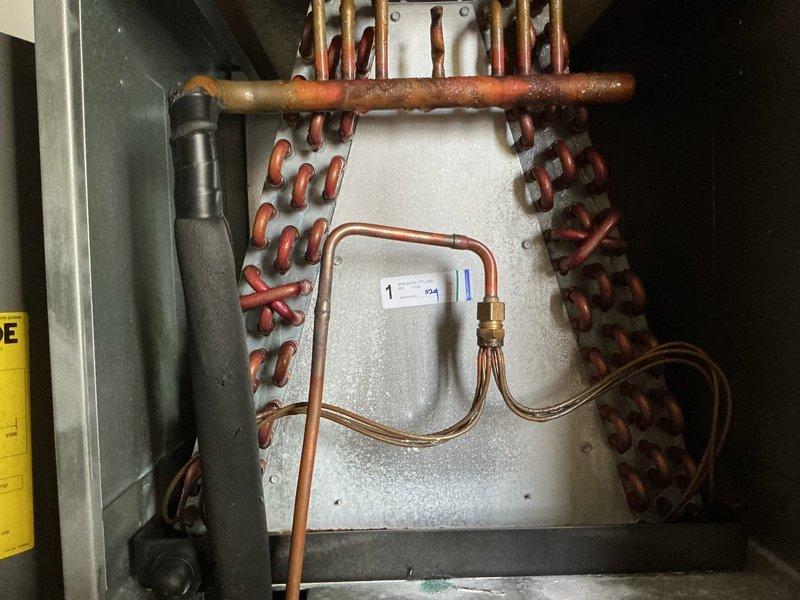 Conducted on-site evaluation for all-electric air handler replacement at residential property with 2200+ square foot heating and cooling system. Existing outdoor Rheem heat pump condenser unit (approximately 2 years old) assessed and determined to be in serviceable condition. Interior air handler located in closet requires replacement to complete split system configuration. Documented existing equipment including evaporator coil assembly with copper refrigerant lines and provided comprehensive estimate for new air handler installation compatible with current outdoor unit specifications.
