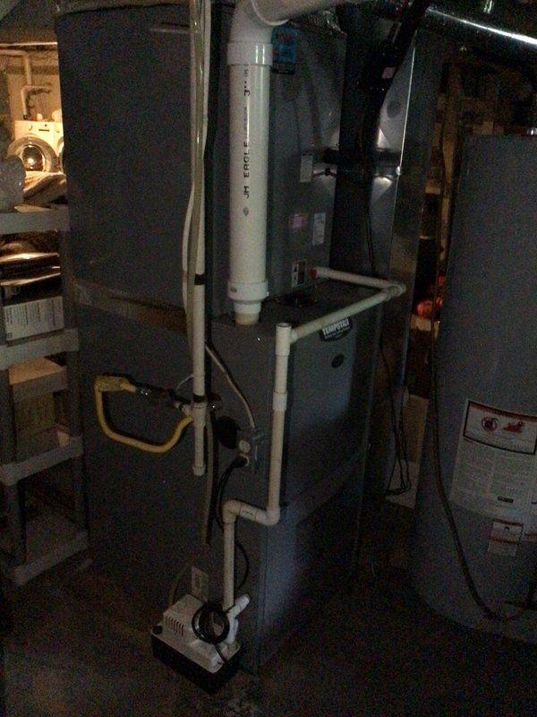 Responded to service call for 15-year-old HVAC system producing excessive noise during operation, described as similar to an off-balance dryer. Upon arrival, performed diagnostic inspection of furnace and associated equipment in basement utility area. Evaluated system operation, inspected blower assembly, motor bearings, and mechanical components to identify source of abnormal sound. System remained operational and cooling effectively throughout inspection. Documented equipment condition including Honeywell thermostat, furnace unit with PVC venting system, and condensate pump assembly.