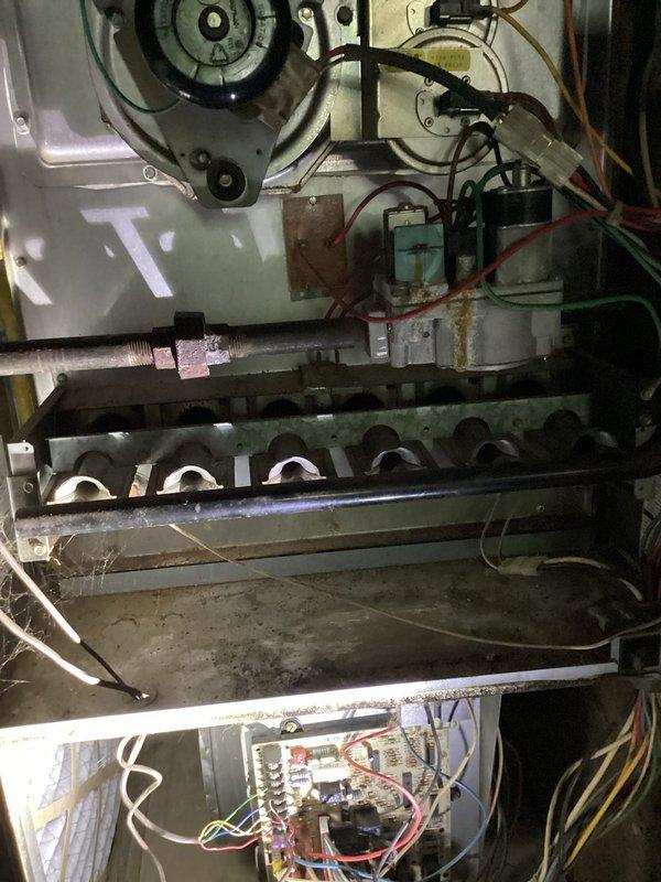 Responded to no-cool call on older gas furnace system located in basement. Upon arrival, confirmed unit was completely non-operational with no power to system. Conducted comprehensive diagnostic inspection of all electrical components, control board, transformer, and safety circuits. Visually inspected blower motor assembly, burner assembly, and all internal mechanical components for signs of failure or damage. Investigated reported occasional gas odor in basement area and performed safety assessment of gas connections and burner manifold. Checked electrical panel breakers and verified proper voltage supply to unit. Examined control board wiring, connections, and circuit integrity throughout system. Documented equipment condition showing significant age-related wear, dust accumulation, and component deterioration. Photographed internal components including blower motor, control boards, burner assembly, and wiring configurations for service records. Provided customer with findings and r