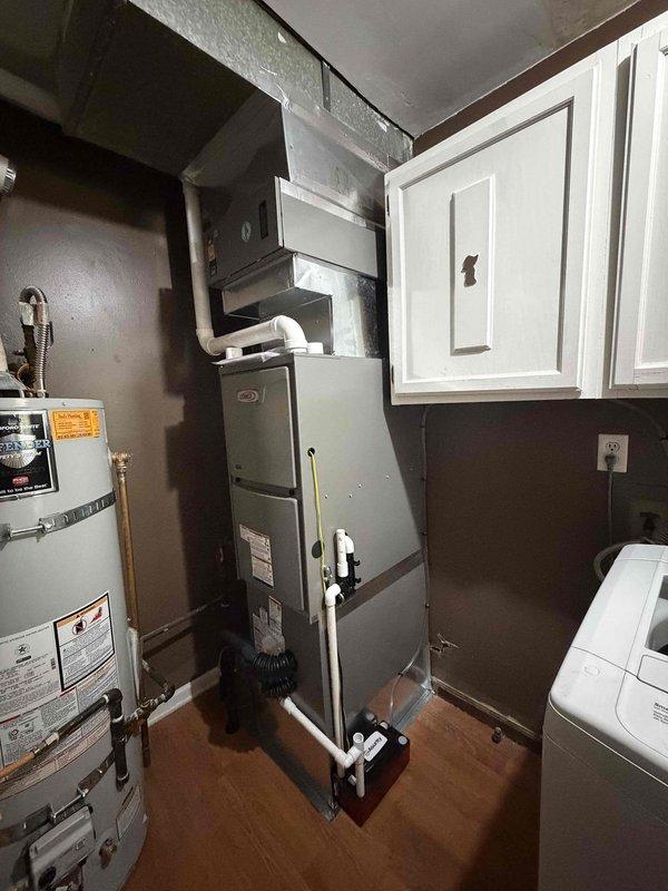 Completed full HVAC system installation including a 2-ton, 15.5 SEER outdoor condensing unit and 96% AFUE gas furnace. The outdoor unit was professionally positioned on a concrete pad against the residence exterior with proper clearances maintained from surrounding landscaping and structures. Electrical disconnect installed and properly mounted to exterior wall with secure conduit connections. Indoor furnace installed in utility area with new PVC venting routed through existing ductwork infrastructure. All refrigerant lines properly sized, insulated, and connected between indoor and outdoor components. System charged to manufacturer specifications and tested for proper operation. Verified airflow, temperature differentials, and combustion efficiency meet required standards. All electrical connections completed to code with proper grounding and circuit protection. Existing water heater and laundry appliances remain accessible with adequate service clearances maintained throughout instal