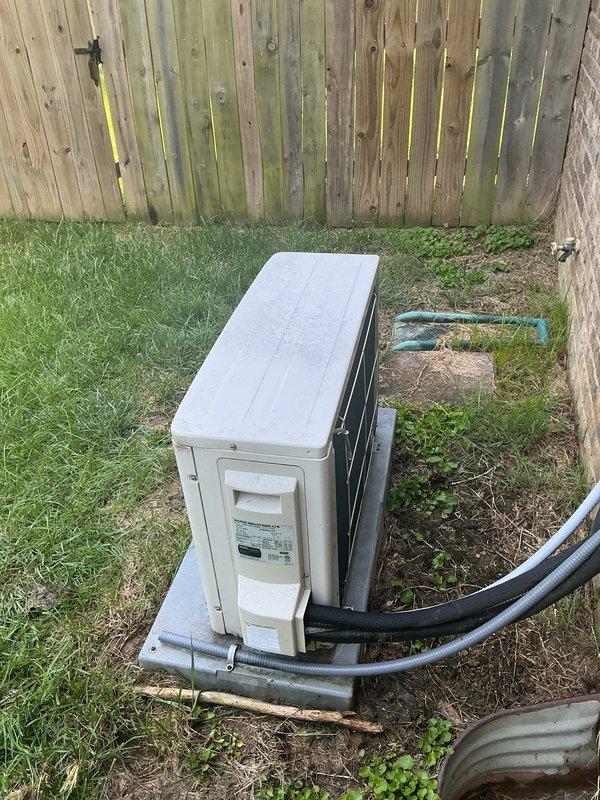 Responded to service call for 8-year-old mini-split system on east end of property experiencing condensation leakage from indoor wall-mounted unit. Upon arrival, performed diagnostic evaluation of the ductless inverter system which had been shut down by occupant due to water dripping concerns. Conducted temperature differential measurements at multiple points on the indoor air handler, recording supply air temperature of 60.3°F and return air readings. Inspected outdoor condenser unit positioned on concrete pad, verified proper operation and refrigerant line connections. No ice buildup was observed on the indoor unit, and main HVAC system remained operational as backup cooling source. Documented system conditions with thermal readings and exterior equipment placement for service records.