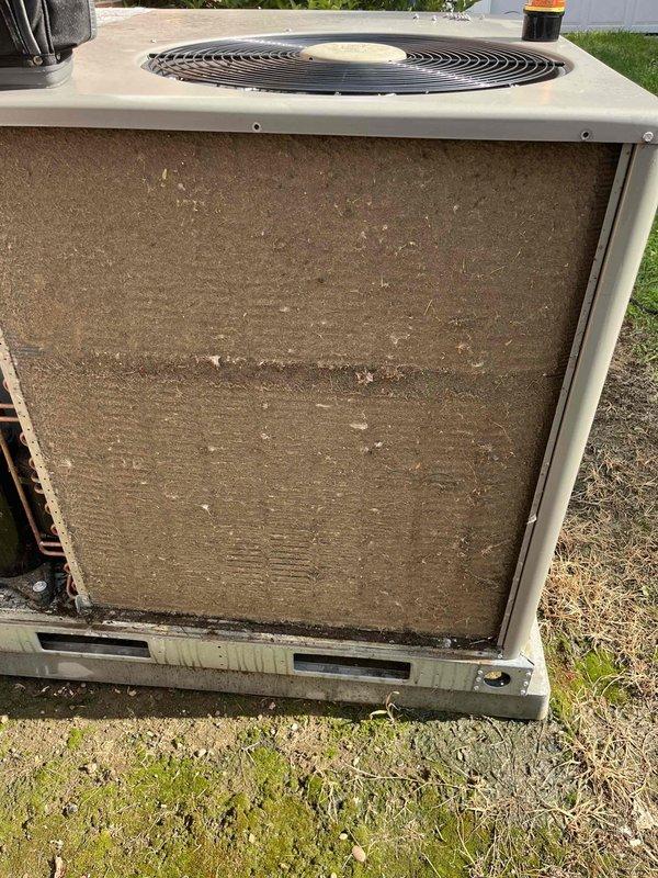 Responded to no cooling complaint on 2-year-old residential AC system affecting entire home. Upon inspection, discovered outdoor unit's air filter completely blocked with heavy accumulation of dirt, dust, and debris, severely restricting airflow and preventing proper system operation. Removed and replaced extremely clogged filter, restoring full airflow to condenser unit. System tested and confirmed cooling properly with adequate airflow and normal operating pressures.