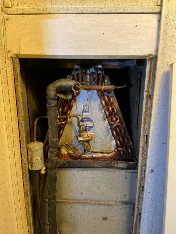 Responded to a no cooling call on a 24-year-old residential HVAC system. Upon arrival, confirmed airflow present but warm air discharge from supply vents. Customer reported intermittent refrigerant odor. Visual inspection revealed severely corroded copper refrigerant lines at evaporator coil assembly with significant oxidation and deterioration of piping connections. Evidence of long-term refrigerant leak consistent with customer observations and loss of cooling capacity. Given the advanced age of the system and extensive corrosion damage to critical refrigerant components, recommended full system replacement as the most cost-effective solution rather than attempting repairs on 24-year-old equipment that has exceeded its expected service life.