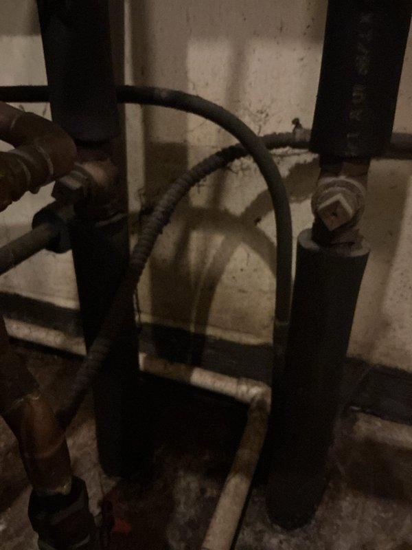 Conducted comprehensive assessment of existing 60+ year old boiler system for replacement estimate. Documented current plumbing infrastructure including aged copper piping with visible oxidation, pressure regulation equipment, and multiple valve assemblies. Evaluated mechanical room conditions and existing pipe configurations to determine scope of work required for new boiler installation. Photographed current system components including corroded metal fittings, black iron piping, and water distribution connections to provide accurate replacement specifications and identify necessary upgrades to bring system up to current code standards.