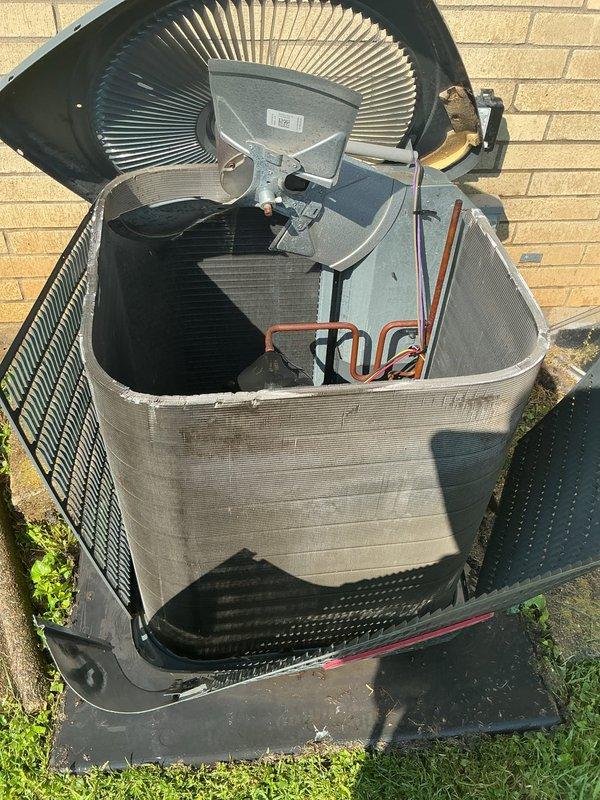 # HVAC Service Completed

Responded to service call for preventive condenser coil replacement on a 57-year-old residential air conditioning system originally installed in 1968-1969. Customer reported no current cooling issues or operational symptoms but requested coil replacement based on recommendation from a previous service technician.

Upon arrival, performed visual inspection of outdoor condenser unit. Opened top access panel to assess internal components including fan blade assembly, refrigerant lines, and condenser coil condition. Examined copper refrigerant tubing, insulated suction lines, and heat exchanger coil through unit louvers. Noted visible debris and dirt accumulation on condenser coil fins, consistent with age and outdoor exposure of unit.

Documented unit condition through photography showing fan motor assembly, internal copper lines, coil configuration, and exterior cabinet condition. Unit mounted on composite pad against exterior wall with adequate clearance. Cabin