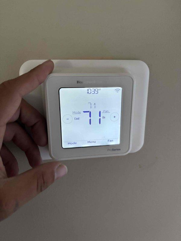 Responded to complaint of loud humming noise from outdoor condensing unit on 5-year-old system. Performed diagnostic evaluation and confirmed system operational with cooling mode active. Verified thermostat settings at 71°F with proper communication to equipment. Measured supply air temperature at 53°F at register, indicating adequate cooling performance. Inspected outdoor unit and noted significant corrosion and deterioration on cabinet panels and metal surfaces, likely contributing to vibration amplification and noise generation. Documented equipment condition with photos showing extensive oxidation, moisture damage, and surface degradation on unit housing.