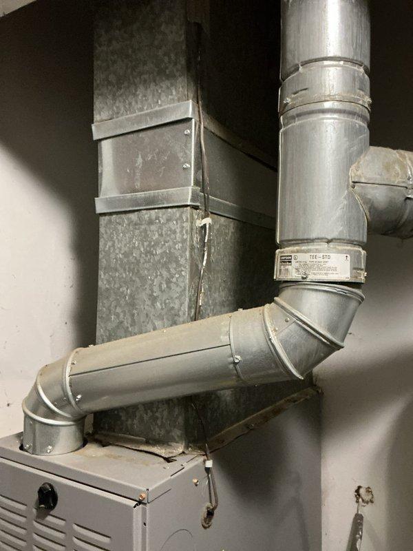 Assessed non-functional air conditioning system that is approximately 17 years old and provided replacement estimate. Documented existing HVAC equipment configuration including furnace installation and ductwork layout in utility area for sizing and equipment specifications.